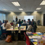 Teachers and mentors collaborating at many tables in a meeting room